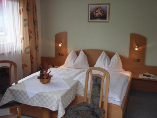 Haus Koller في كابرون: غرفة فندقية بسرير وطاولة وكراسي