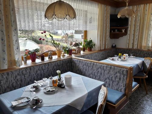 Haus Koller في كابرون: غرفة طعام مع طاولتين ونافذة