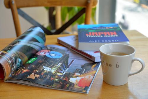 a cup of coffee next to a book and a cup of coffee at the b sangenjaya in Tokyo