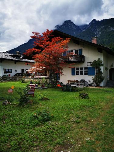 a house with a red tree in front of it at Mountain Hideaway in Garmisch-Partenkirchen