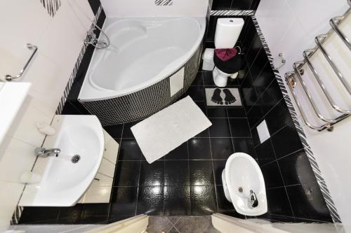 łazienka z wanną, toaletą i umywalką w obiekcie BV Apartments Black&White w Lwowie