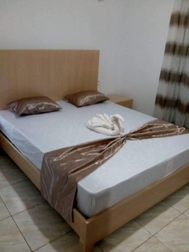 a bed with a wooden headboard and pillows on it at Villa de luxe avec piscine privée sans vis à vis à Djerba in Aghīr