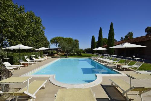 a large swimming pool with lounge chairs and umbrellas at Fattoria San Lorenzo in Grosseto