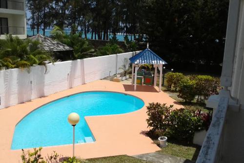 a small swimming pool with a gazebo in a yard at Casa Marina- Flic en Flac - Beach is right in front of the Villa-Just cross the road in Flic-en-Flac