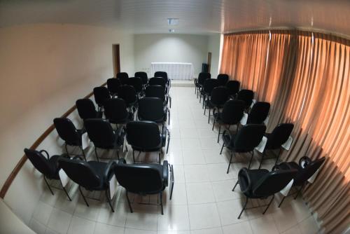 a row of chairs in a room with an orange curtain at Panorama Hotel in Juazeiro do Norte