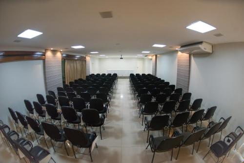 an empty room with chairs and a white wall at Panorama Hotel in Juazeiro do Norte