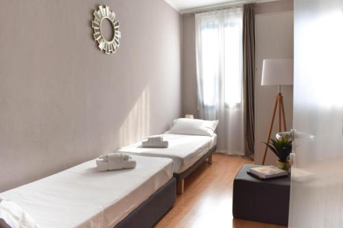 a hotel room with two beds and a mirror at Welc-oM Casa Anna in Padova