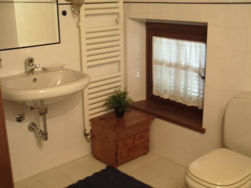 a bathroom with a sink and a toilet and a window at B&B Casa Villa Siviglia in Marliana