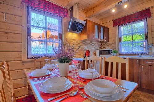 ein Esszimmer mit einem Tisch mit Tellern und Weingläsern in der Unterkunft DOMKI NA WCZASOWEJ in Szczyrk