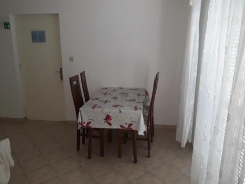a table and chairs in a room with a tablecloth on it at Apartments Beg in Rab