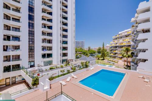 an apartment with a swimming pool in the middle of two tall buildings at Algamar Apartment - Vilamoura Center in Vilamoura