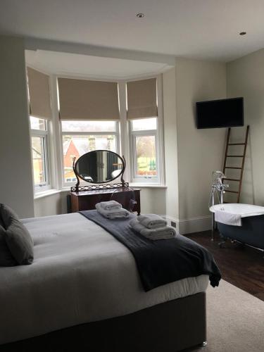 a bedroom with a bed and a tub and a window at Avenue House in Bakewell