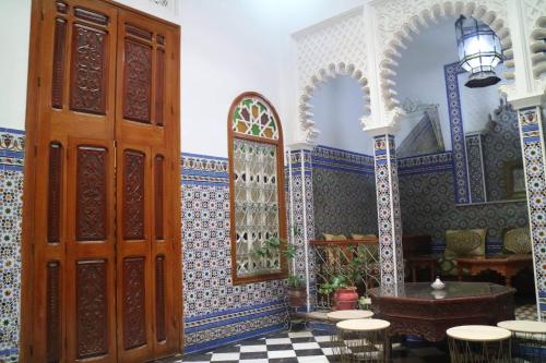 a room with a large door and a table and chairs at Riad Soul of Tetouan in Tetouan