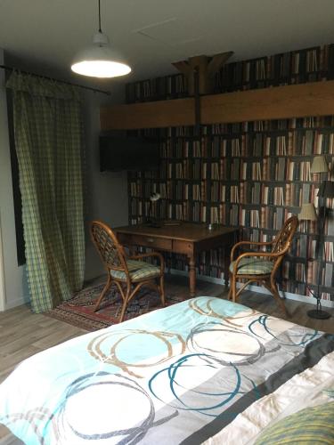 Una habitación con una cama grande y sillas y una biblioteca. en chambre d'hôtes du Luquet, en Chazelles