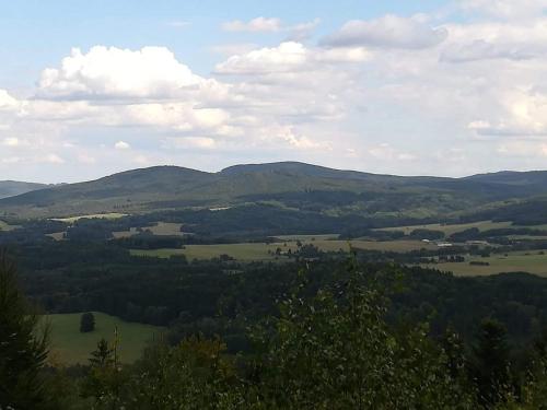 a view of a valley with mountains in the distance at Novohradské hory - pronájem na samotě u lesa in Benešov nad Černou