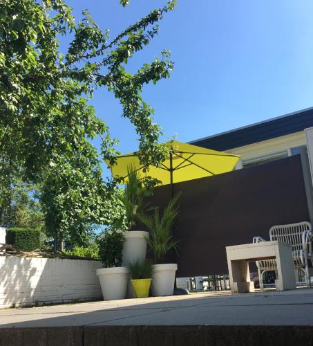 a yellow umbrella sitting on the side of a house at De Tuinkamer-----Privé diner op de kamer mogelijk!!! in Hoogeveen