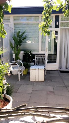 a porch with two white benches on a house at De Tuinkamer-----Privé diner op de kamer mogelijk!!! in Hoogeveen
