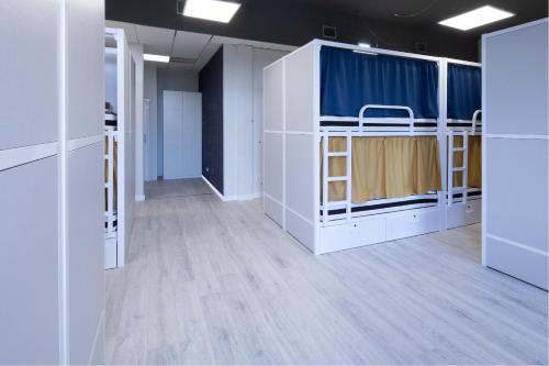 a room with white bunk beds and a blue curtain at Dream in Santiago in Santiago de Compostela