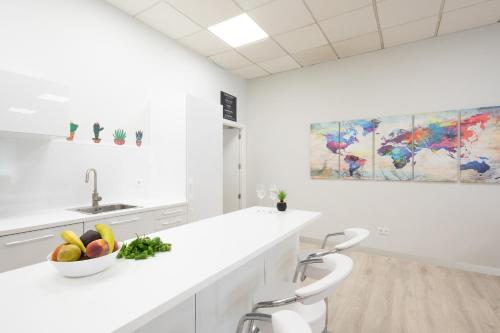 a white kitchen with a bowl of fruit on a counter at Dream in Santiago in Santiago de Compostela