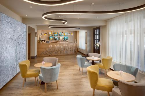 a restaurant with tables and chairs and a counter at Hotel Clement in Prague