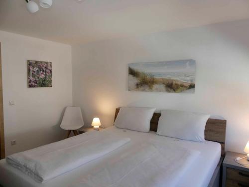 a bedroom with a large white bed with two lamps at FeWo Zum Kuhturm in Günzburg