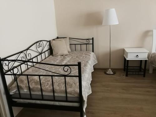 a bedroom with a black bed with a lamp and a table at Vacation in druskininkai in Druskininkai