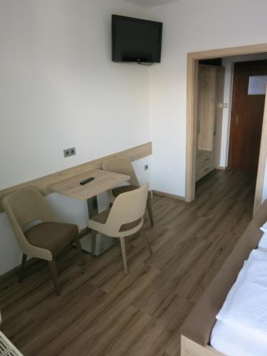 a room with a table and chairs and a bed at Pension Lang in St. Andrä am Zicksee