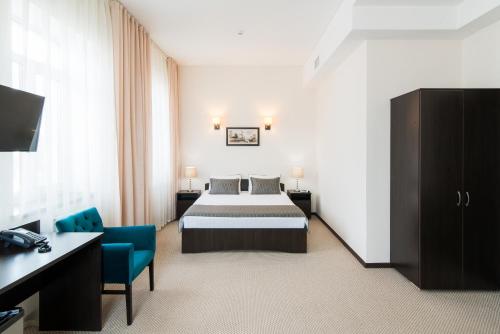 um quarto de hotel com uma cama e uma secretária em Maksim Gorkiy Hotel em Kazan