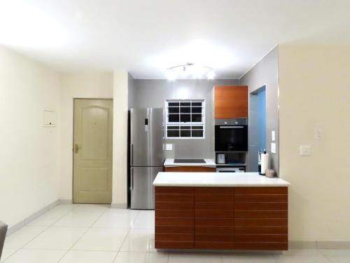a kitchen with a refrigerator and a counter top at Embassy Gardens 17 West Rd South Morningside Sandton Johannesburg Secure 2 Bedroom fully furnished apartment with 24hrs security in Johannesburg