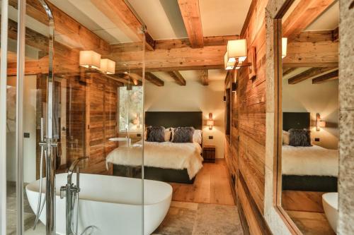 baño con bañera y 2 camas en HelloChalet - Chalet Seventy One - Larger Family Ski Chalet in the center en Valtournenche