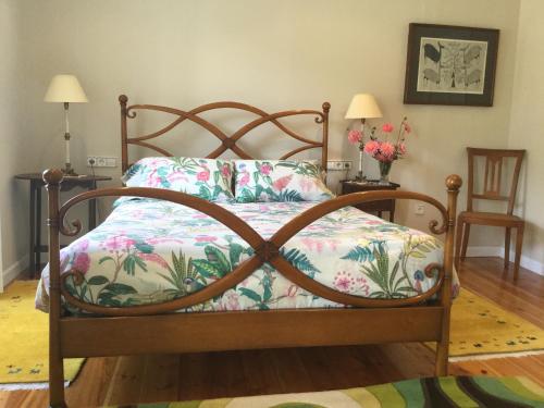 a bed with a wooden frame with a pillow and flowers at Villa Elena in Potes