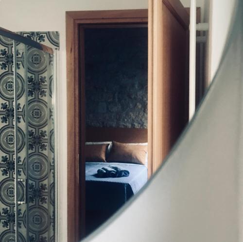 a bedroom with a bed through a mirror at La Vecchia Posta B&B in Calangianus
