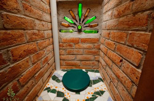 a bathroom with a green toilet in a brick wall at Hostal Pakay in Tena