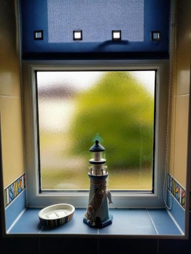 a window with a bottle sitting on a window sill at Bray Cottage in Sidmouth
