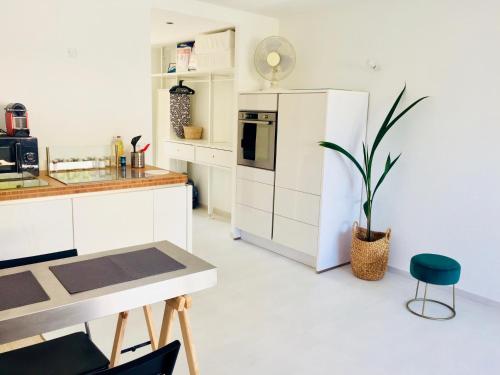 a kitchen with a white refrigerator and a table at ★★★ Paradis Prado Mermoz proximité Mer★★★ in Marseille