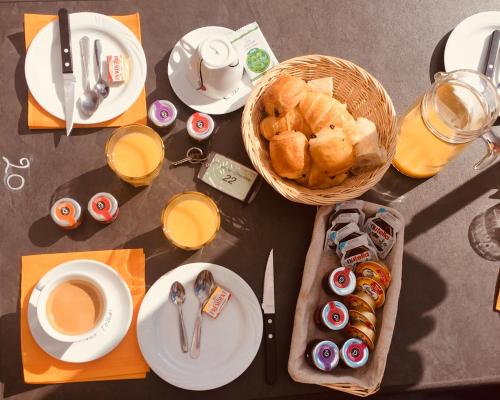 una mesa con comida y una cesta de pan y café en MARIUS, en Aydat