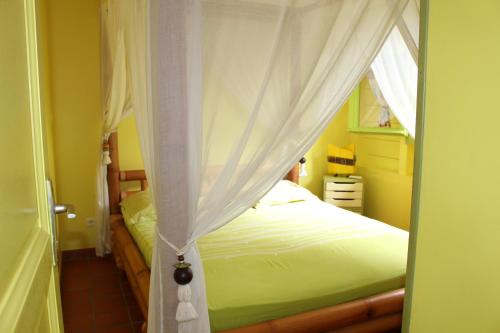 - une chambre avec un lit et un rideau dans l'établissement VILLA SOKA, à Les Anses-d'Arlet