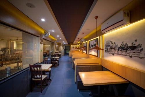 a row of tables and chairs in a restaurant at Sri Udupi Hotel in Trivandrum