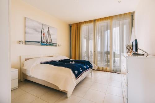 a bedroom with a bed and a tv and a window at Villa Georgina in Badacsonytomaj