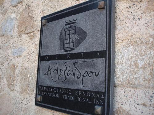 una señal en el costado de una pared de piedra en Oikia Alexandrou Traditional Inn, en Arnaia
