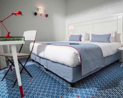a bedroom with a large bed and a table and a desk at Hotel 34B - Astotel in Paris