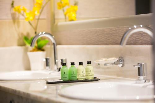 Un lavabo con tres botellas verdes. en PLATINUM HOTEL CASINO en Charata
