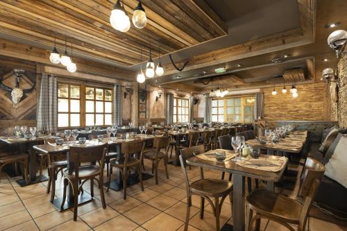 a restaurant with wooden walls and tables and chairs at Résidence Les Balcons de Val Thorens & Spa in Val Thorens