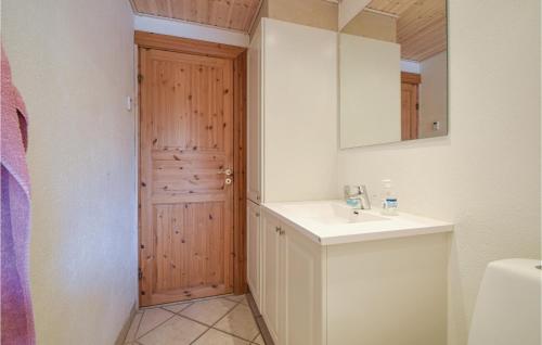 baño con lavabo, espejo y puerta en Nice Home In Randbl With Kitchen, en Randbøl
