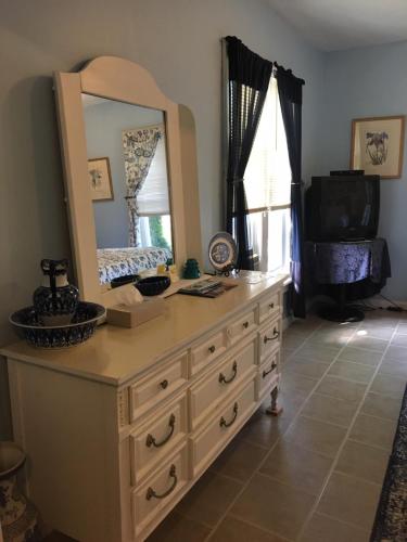 a dresser with a mirror on top of it at Glass Magnolia Bed & Breakfast in Interlaken