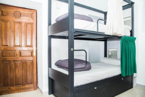 Habitación con litera y puerta en Onefam Catedral, en Sevilla