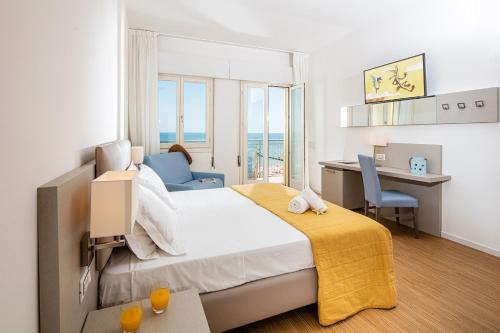 a hotel room with a bed and a desk and chair at Hotel Astor in Lido di Jesolo