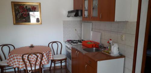 a kitchen with a table and a small kitchen with a table and chairs at Apartment Perović in Baška Voda