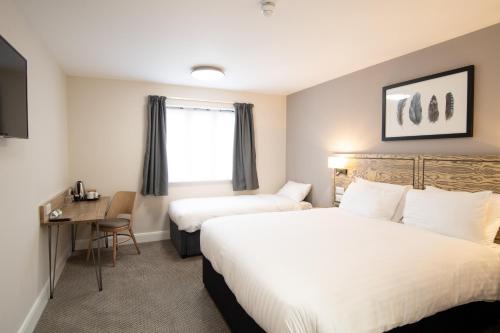 a hotel room with two beds and a desk at Paisley Pear, Brackley by Marston's Inns in Brackley