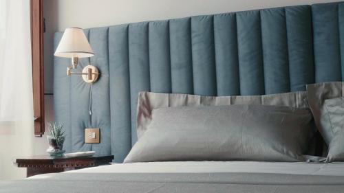 a bedroom with a large bed with a blue headboard at Dimora Decò in Lugo